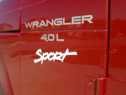 1998 Jeep TJ - Close-up of the side panel on a red Jeep Wrangler, showing the '4.0 L Sport' badging.