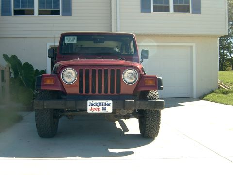 1998 Jeep TJ - A red Jeep Wrangler is parked in front of a house with a garage.