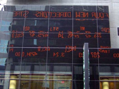 1995 Ford Bronco - Digital stock ticker display on a building facade shows financial data in orange text.