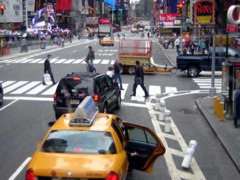 1995 Ford Bronco - A busy street scene in Times Square with multiple vehicles and pedestrians.