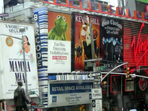 1995 Ford Bronco - A busy Times Square scene with multiple large digital billboards advertising various entertainment acts and products.