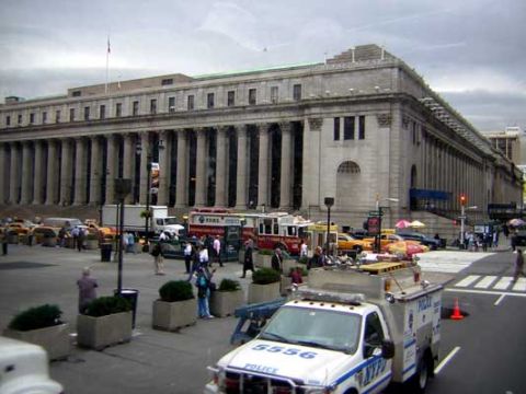 1995 Ford Bronco - A police truck is parked on a street in front of a large building with columns, with other vehicles and pedestrians around.