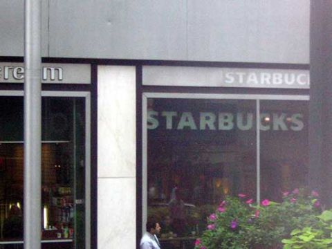 1995 Ford Bronco - A Starbucks storefront with signage visible on the exterior and interior reflections.