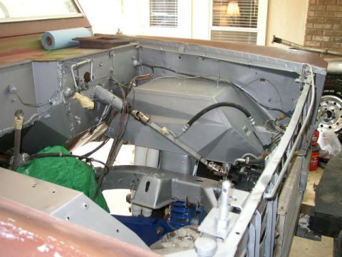 1995 Ford Bronco - The engine bay of a vehicle shows various hoses, wiring, and mechanical components during what appears to be a restoration or repair proces…