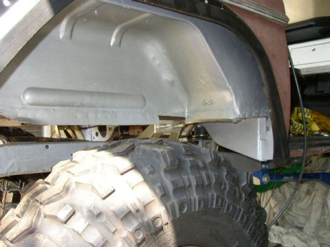 1995 Ford Bronco - The underside of a vehicle, focusing on the wheel well and a large tire, with some repair work visible.