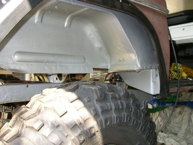 close-up of a large off-road tire and the inside of a vehicle's wheel well