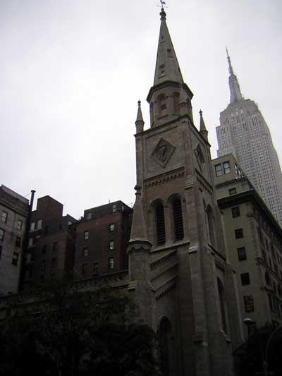 1995 Ford Bronco - A church spire stands tall in the foreground, with the iconic Empire State Building visible in the background on an overcast day.
