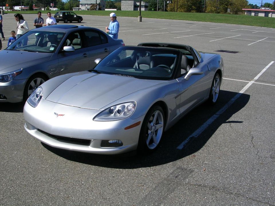 Silver C6 Corvette with roof panel removed at a parking lot car meet
