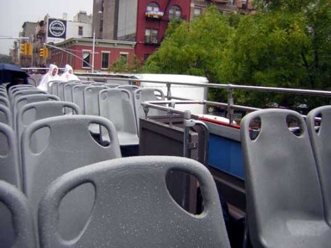1995 Ford Bronco - Interior view of an open-top bus with multiple rows of seats and two passengers in the background.
