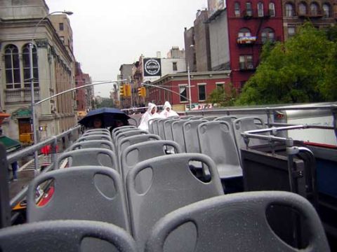 1995 Ford Bronco - View from the upper deck of a double-decker bus shows rows of empty seats on a rainy day in the city.