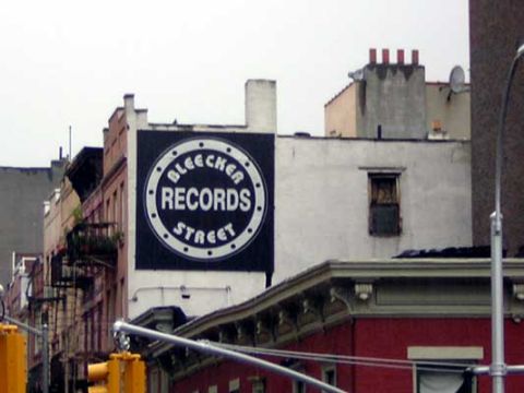 1995 Ford Bronco - A large circular sign for Bleecker Records Street is visible on the side of a building.