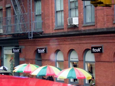 1995 Ford Bronco - A street scene shows a brick building with multiple storefronts and colorful umbrellas providing shade.