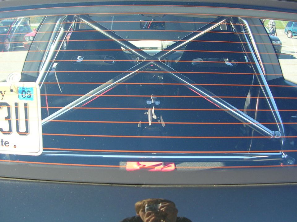 Interior view of a car with a roll cage visible through the rear window. License plate reads '30U'