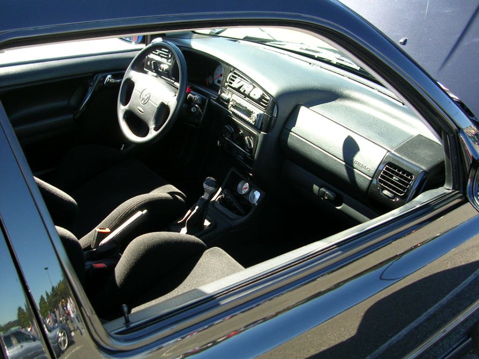 Interior of a 1996 Volkswagen GTI, showing the dashboard, steering wheel, seats, and gear shifter