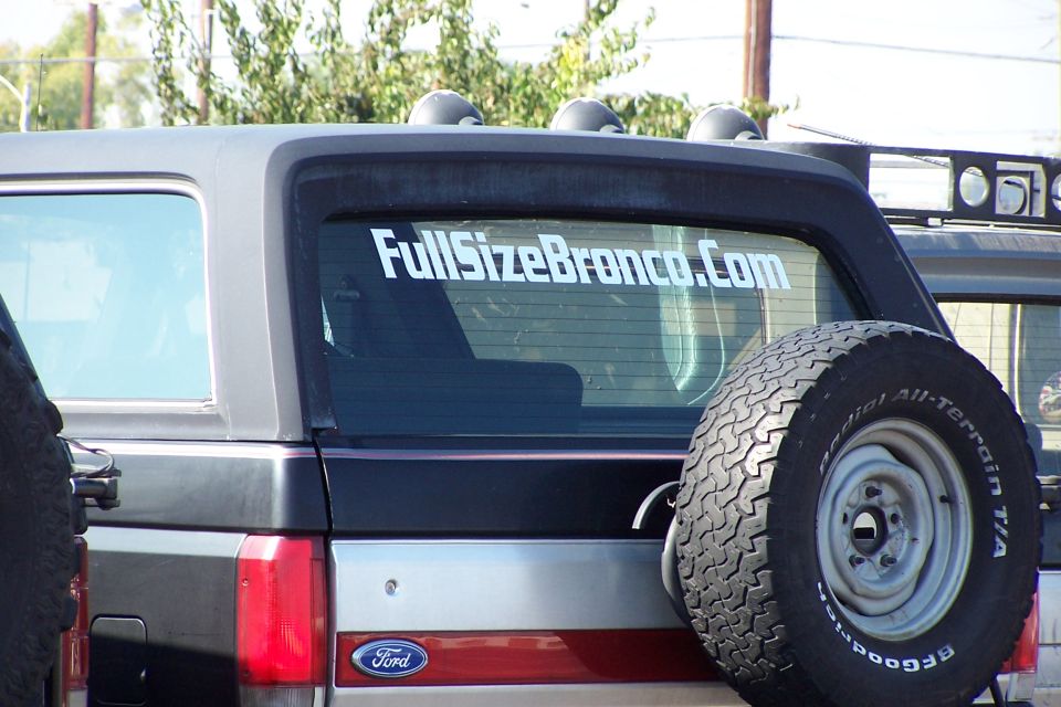 Rear of a 1990 Ford Bronco with a spare tire and a "FullSizeBronco.com" sticker on the window