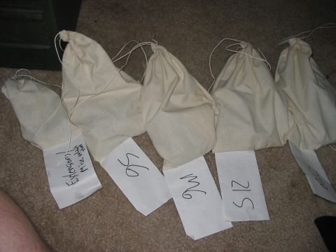 1988 Ford Bronco - Several cloth bags, some with handwritten labels like "Extensions" and numbers, are laid out on a carpeted floor.