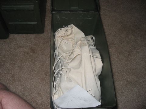 1988 Ford Bronco - Contents of an open ammo can are covered by a cloth bag tied with string.