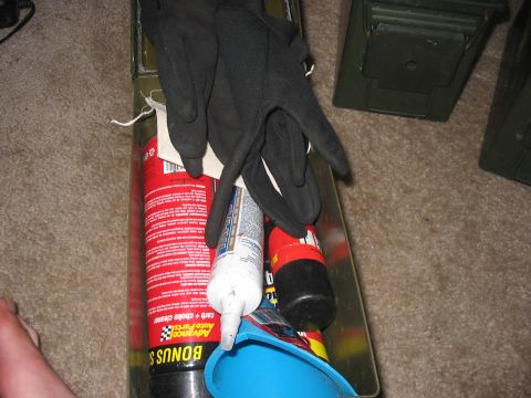 1988 Ford Bronco - Automotive supplies including gloves, cleaner, and a funnel are stored in a metal box.