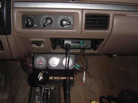 1993 Ford Bronco - Dashboard interior a CB radio and auxiliary gauges, including a tachometer.