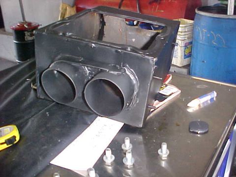 1992 Ford Bronco - A custom exhaust part with dual pipes sits on a metal surface next to a tape measure and bolts.