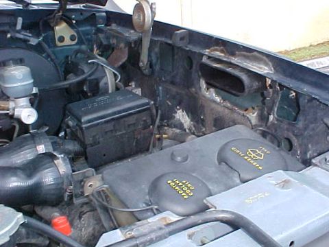 1992 Ford Bronco - Close-up view of the engine bay, highlighting the coolant reservoir and fuse box.