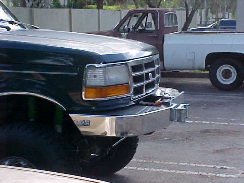 1992 Ford Bronco - Front view of a 1992 Ford Bronco, with another truck visible in the background.
