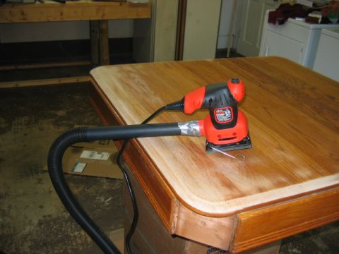 1985 Ford LTD Crown Victoria - An orbital sander is being used to refinish a wooden table.