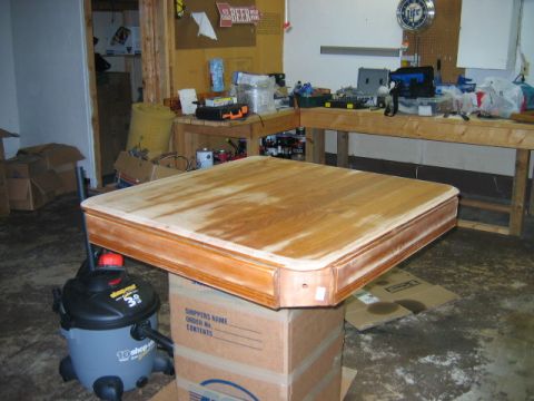 1985 Ford LTD Crown Victoria - A wooden table top is elevated on cardboard boxes, with a shop vac nearby and a workbench visible in the background.