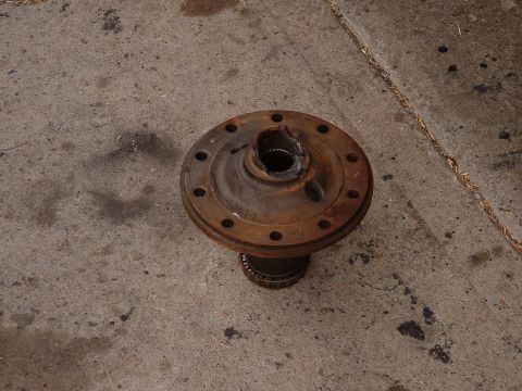 1990 Ford Bronco - A rusty differential housing sits on a concrete surface, showing signs of wear and age.