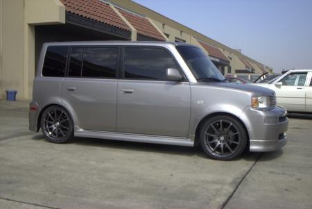 1993 Ford Taurus - Side view of a modified Scion xB, parked next to another vehicle.