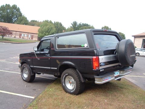 1993 Ford Bronco - This black Ford Bronco is seen from the rear 3/4 angle, with a spare tire mounted on the back.