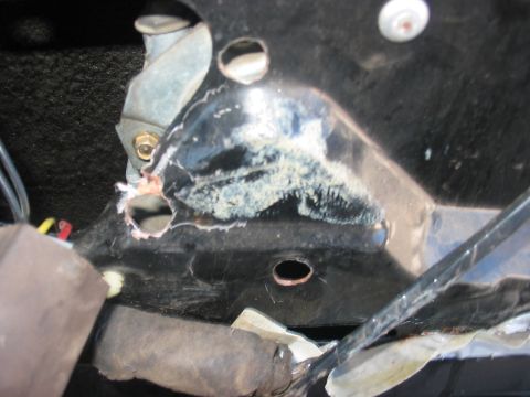 1988 Ford Bronco - Close-up view of a corroded power window mechanism bracket, showing mounting points and internal components.
