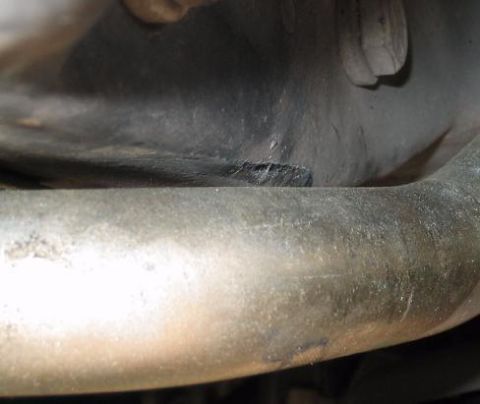 1999 Ford Crown Victoria - Undercarriage view showing an exhaust pipe and surrounding components. SUPERMOTORS.NET logo is present.