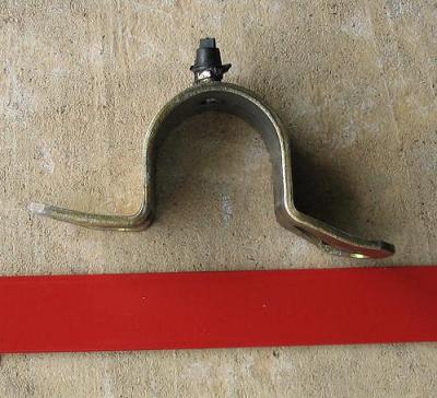 1999 Ford Crown Victoria - A metal bracket with a black plastic clip is shown against a concrete background, with a red bar below and a Supermotors.net logo at the bo…