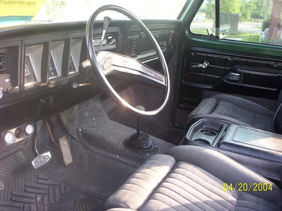 Green 1978 Ford Bronco interior, showing dashboard, steering wheel, seats, and floor shifter