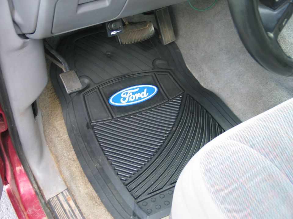 Black rubber Ford floor mat on driver side carpet of a vehicle