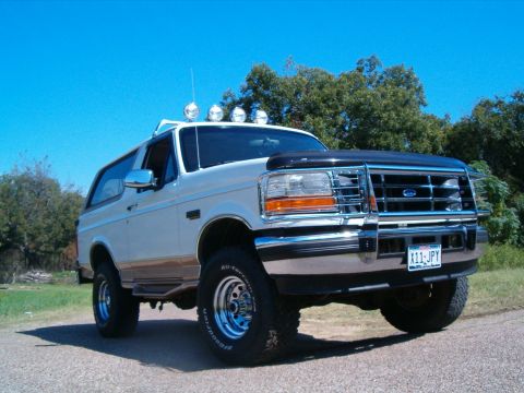 1996 Ford Bronco - This 1996 Ford Bronco features a prominent chrome grille, off-road lights mounted on the roof, and BFGoodrich All-Terrain tires.