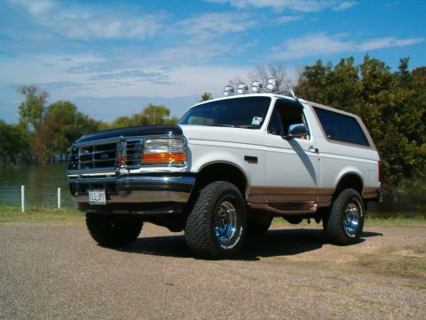 1996 Ford Bronco - This 1996 Ford Bronco is parked outdoors near a lake under a partly cloudy sky.