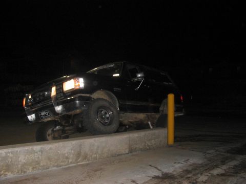 1988 Ford Bronco - This 1988 Ford Bronco is shown driving over a concrete curb at night.