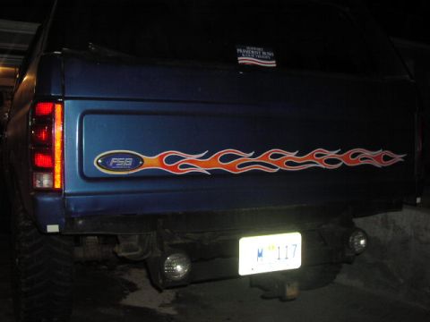 1981 Ford Bronco - Blue SUV rear view with flame decals and a 'Support President Bush' sticker.