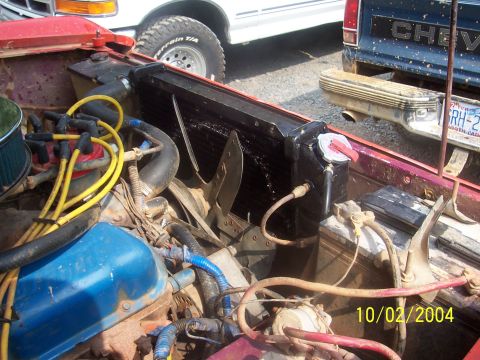 1994 Jeep YJ - Close-up view of a vehicle's engine bay, focusing on the radiator and various hoses and electrical components. The image includes a date st…