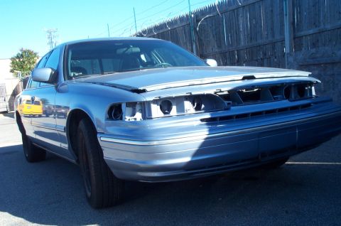 1991 Ford LTD Crown Victoria - A blue sedan, likely a 1992 model, sits with its front end damaged and parts missing.