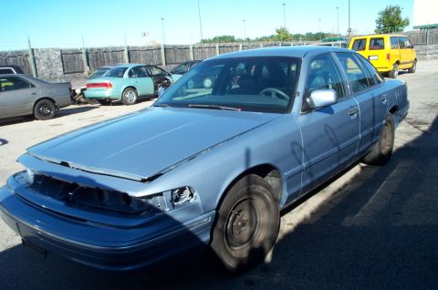 1991 Ford LTD Crown Victoria - A blue 1991 Ford Crown Victoria LTD is parked outside with its hood open and missing headlights.