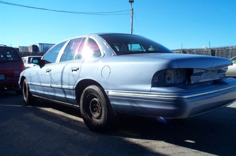 1991 Ford LTD Crown Victoria - This sedan is missing its rear taillights and appears to be undergoing repairs or is being dismantled.