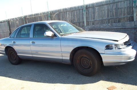 1991 Ford LTD Crown Victoria - This 1991 Ford Crown Victoria LTD sedan is seen from the front three-quarter view with its hood open and headlights missing.