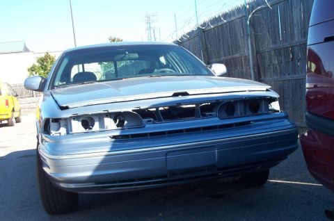 1991 Ford LTD Crown Victoria - Front end of a blue Ford Crown Victoria, missing grille and headlights, parked outdoors.