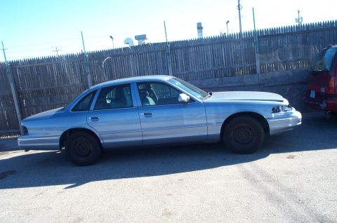 1991 Ford LTD Crown Victoria - Side view of a light blue sedan with its hood open, parked outdoors next to another vehicle.