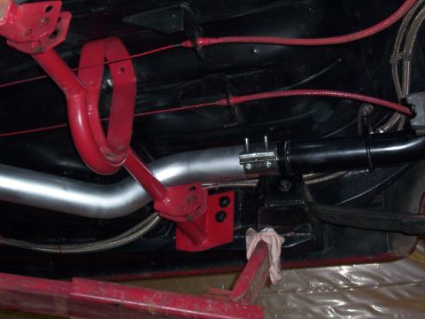 1963 Ford Fairlane - Close-up of the undercarriage showing red painted suspension components and a silver exhaust pipe.
