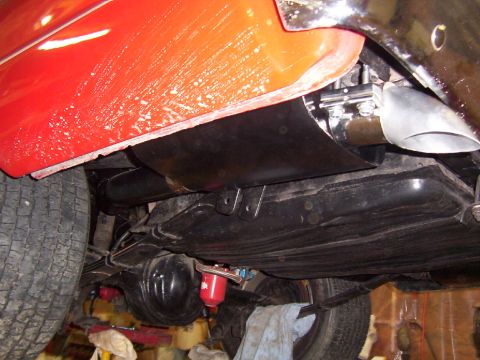 1963 Ford Fairlane - Underside view of a red vehicle, highlighting the fuel tank, exhaust system, and rear axle components.