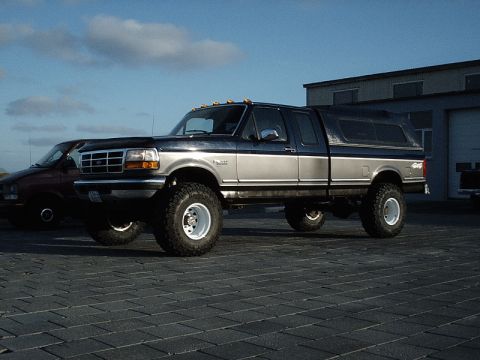 1996 Ford Bronco - Lifted 1996 Ford Bronco with a camper shell parked outdoors.